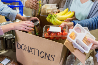 a bag labeled donations with food being put into it